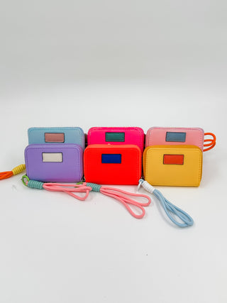 Set of colorful mini wallets with wrist straps and label details