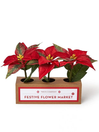Faux poinsettia set with red flowers in a wooden planter with three potted stems