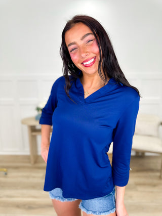 Lightweight 3/4 sleeve V-neck top in navy blue, worn with denim shorts.