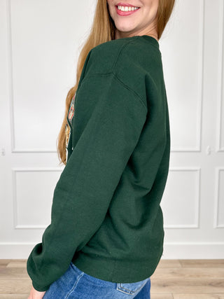 Green crewneck sweatshirt with long sleeves, side view, front graphic not visible
