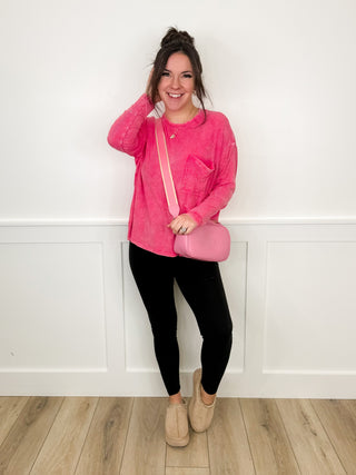 Pink long-sleeve tunic top with front pocket, black leggings, tan ankle boots