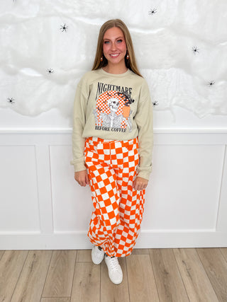 Beige graphic sweatshirt with orange checker pajama pants