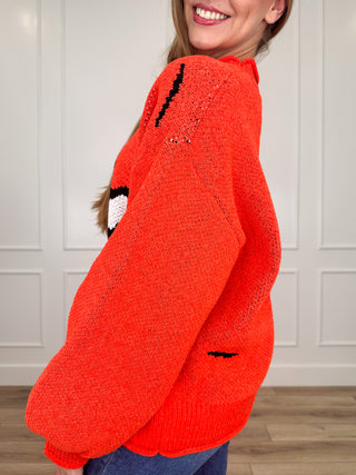 Orange knit long-sleeve sweater, side view, ribbed cuffs and hem