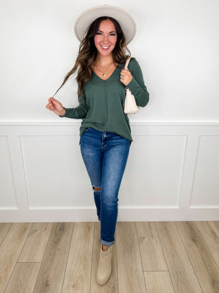 Casual green long-sleeve V-neck blouse with blue distressed skinny jeans