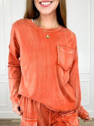 Rust orange cotton long-sleeve top with crew neck and chest pocket