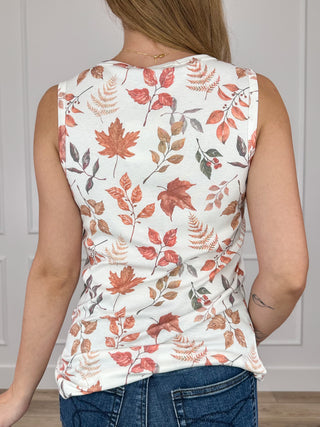 Ivory sleeveless tank top with scoop back and rust, orange, green leaf floral print