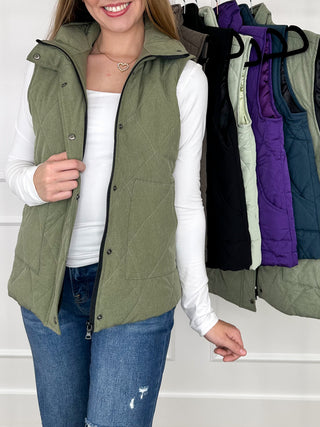 Olive green hooded quilted puffer vest with button front and curved hem