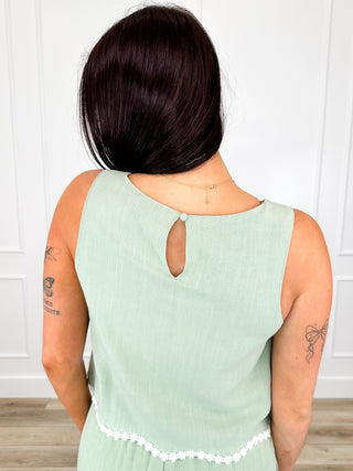 Sage green sleeveless tank top with keyhole open back and white trim