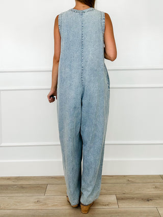 Light wash denim jumpsuit, sleeveless back view with wide-leg pants and buttoned seams