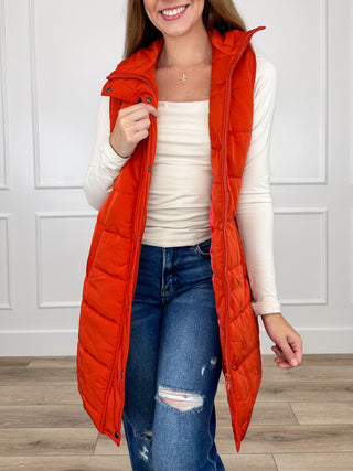 Bright orange sleeveless puffer vest with hood and front button placket