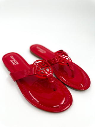 Red thong sandals with glossy finish and caged knot cutout buckle strap