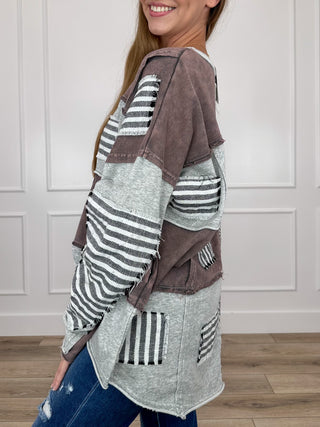 Patchwork long-sleeve top with grey paneling, brown sleeves, striped patch pockets