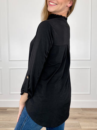 Black gabby top with 3/4 sleeves, V-neck, and slightly curved hem