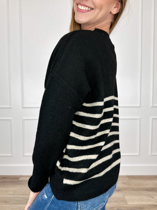 Black long-sleeve knit sweater top with cream stripe bands along the side