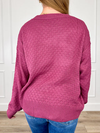Purple knit sweater top, back view with textured stitch pattern, ribbed hem