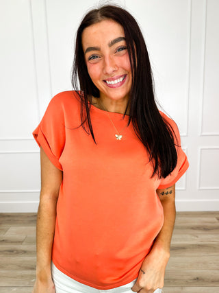 Lightweight short-sleeve top in coral orange, crew neck, draped gathered hem