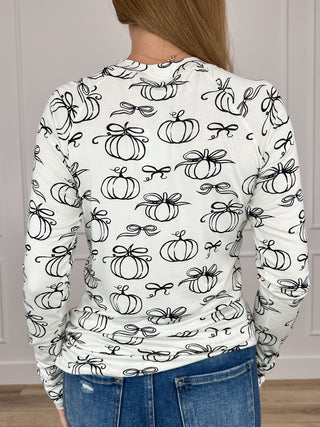 Back view of long-sleeve pumpkin-print top in white with black outline graphics