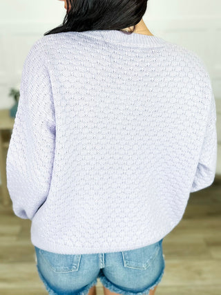 Light-colored textured knit long-sleeve sweater with crew neck, back view