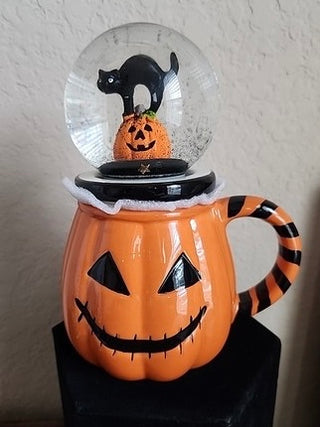 Orange ceramic globe mug with jack-o-lantern face and black cat snow globe lid