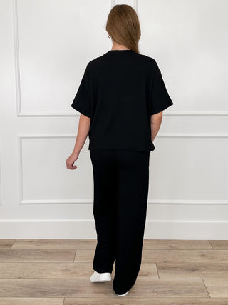 Black ribbed high-rise lounge set, back view of short-sleeve top and drawstring joggers