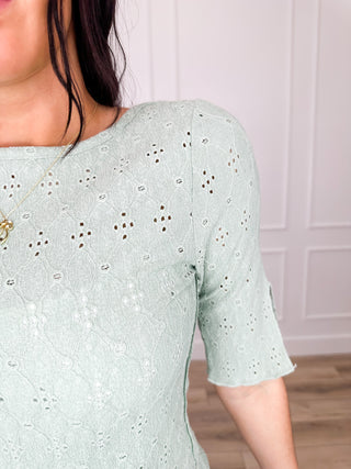 Green 3/4 sleeve knit top sleeve detail with eyelet perforated pattern