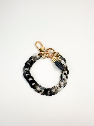 Black and gray chain wristlet keychain with gold clasp and tassel charm