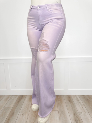 Lavender jeans with a distressed knee on a white background