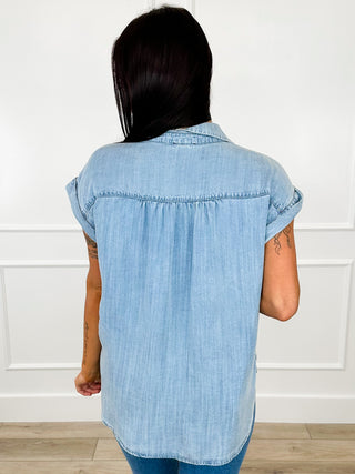 Medium wash denim short-sleeve button-up top with back yoke seam, back view