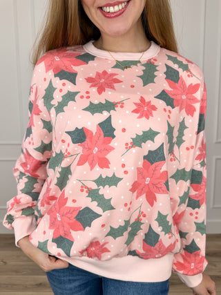 Pink knit long-sleeve top with poinsettia floral print and crew neckline
