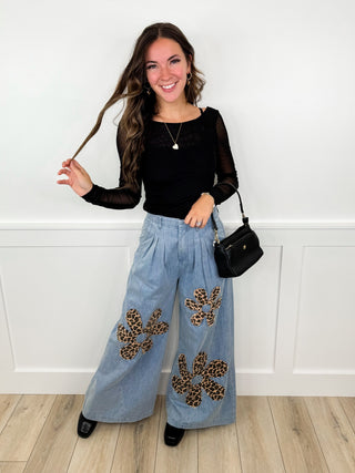 Black long-sleeve top with light-blue wide-leg skirt and dark butterfly appliques