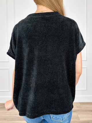 Black knit short-sleeve top shown from back, relaxed fit
