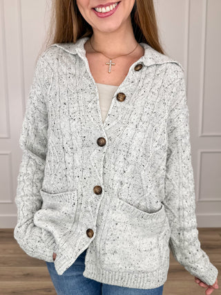 Light grey knit cardigan with button front and ribbed collar, long sleeves, side pockets