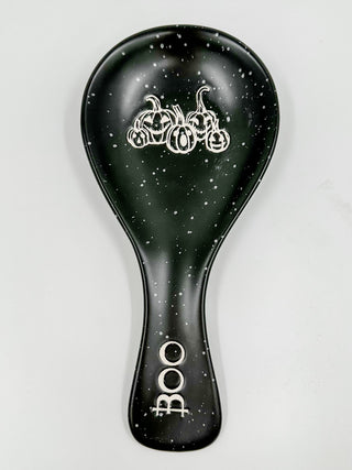Black ceramic spoon rest with speckled finish and white spooky characters