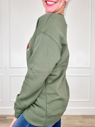 Green crewneck sweatshirt shown from the side, with long sleeves and a ribbed hem