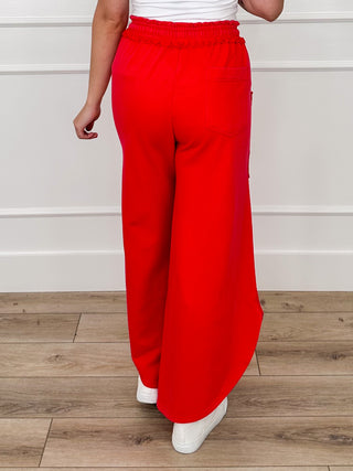 High-rise red cotton-blend pants with drawstring waist and side cargo pockets
