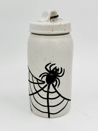 White ceramic storage canister with black spider and web design, lidded top