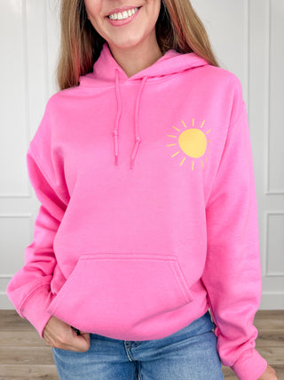 Pink pullover hoodie with front sun graphic and drawstring hood, long sleeves