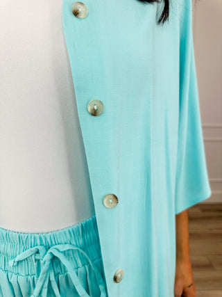 Blue button-front top close-up with gold snaps and drawstring waist pants