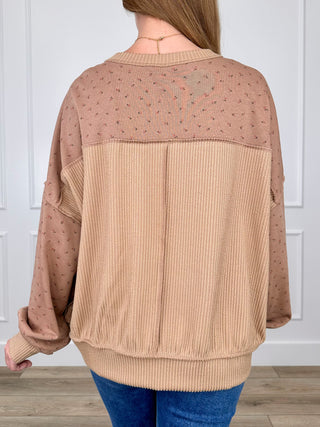 Back view long sleeve knit top with dot pattern and ribbed contrast yoke panel.