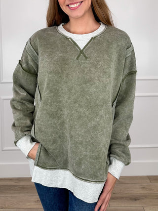 Women's olive green long-sleeve V-neck pullover top with contrast white hem and cuffs
