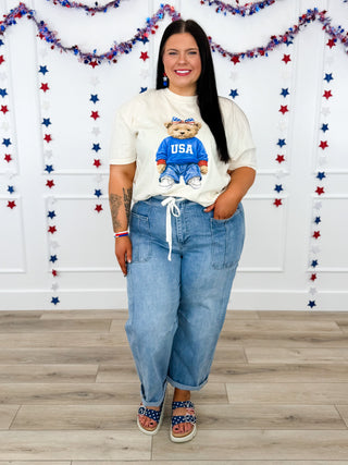 White graphic T-shirt and light-wash denim jeans outfit with front tie waist