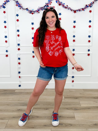 Red graphic T-shirt, denim shorts, colorful sneakers, bow headband.