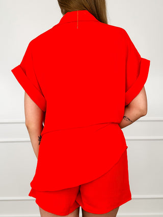 Bright orange high-rise shorts set with matching button-front shirt, back view