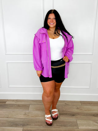 Purple jacket with white top and black shorts, plus striped sandals