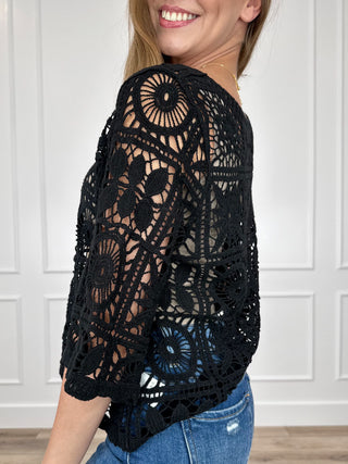 Black crochet short-sleeve top, side view with open lace circular pattern