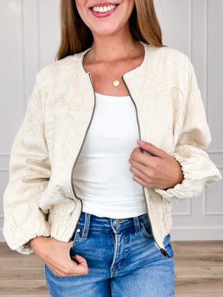 Cream cotton long-sleeve jacket with front zipper and embroidered texture, ruffled cuffs