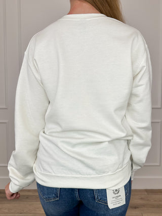White crewneck sweatshirt back view, ribbed hem and small logo tag near hem