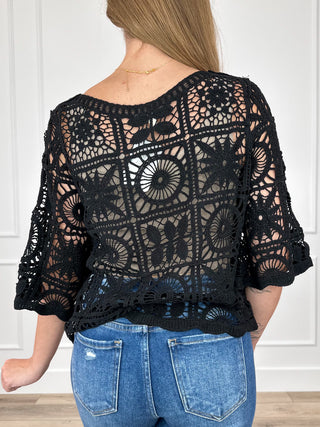 Black crochet short-sleeve top, back view with circular lace motifs and scalloped hem