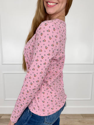 Pink long-sleeve floral print top with curved hem and button-front placket
