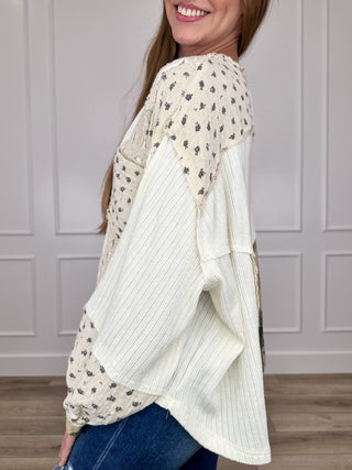 Ivory long-sleeve cropped top with dotted sleeves and loose draped side